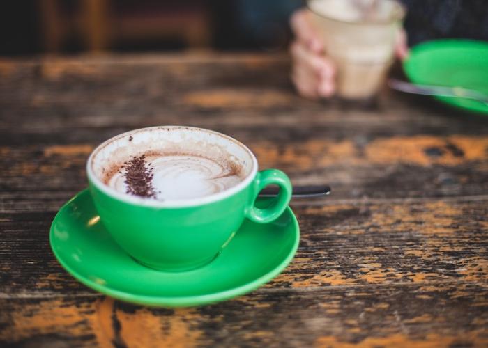 Solo bright green cup of foamy coffee
